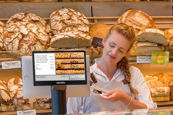 Bäckerei-Verkäuferin scannt Kundenkarte an Vectron-Kassensystem 