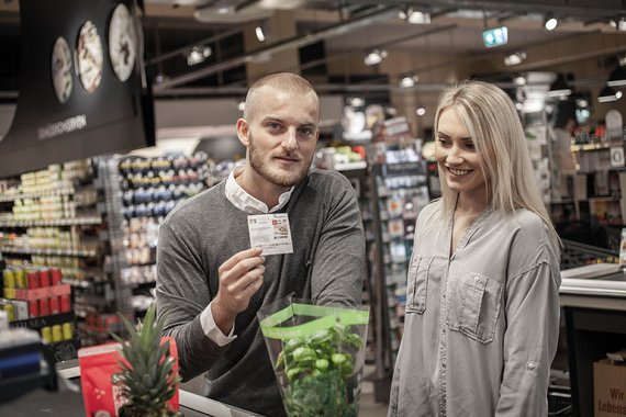 Couple with acardo paper coupon at the supermarket