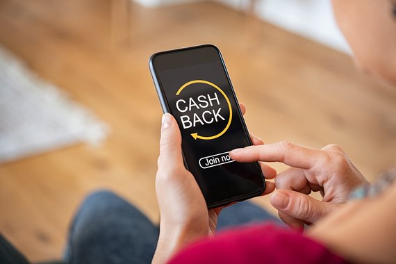 Person mit Smartphone und Cashback-App auf dem Display